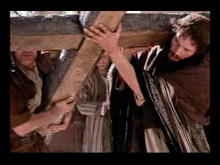 El Cirineo ayuda a Jesús a llevar la cruz.